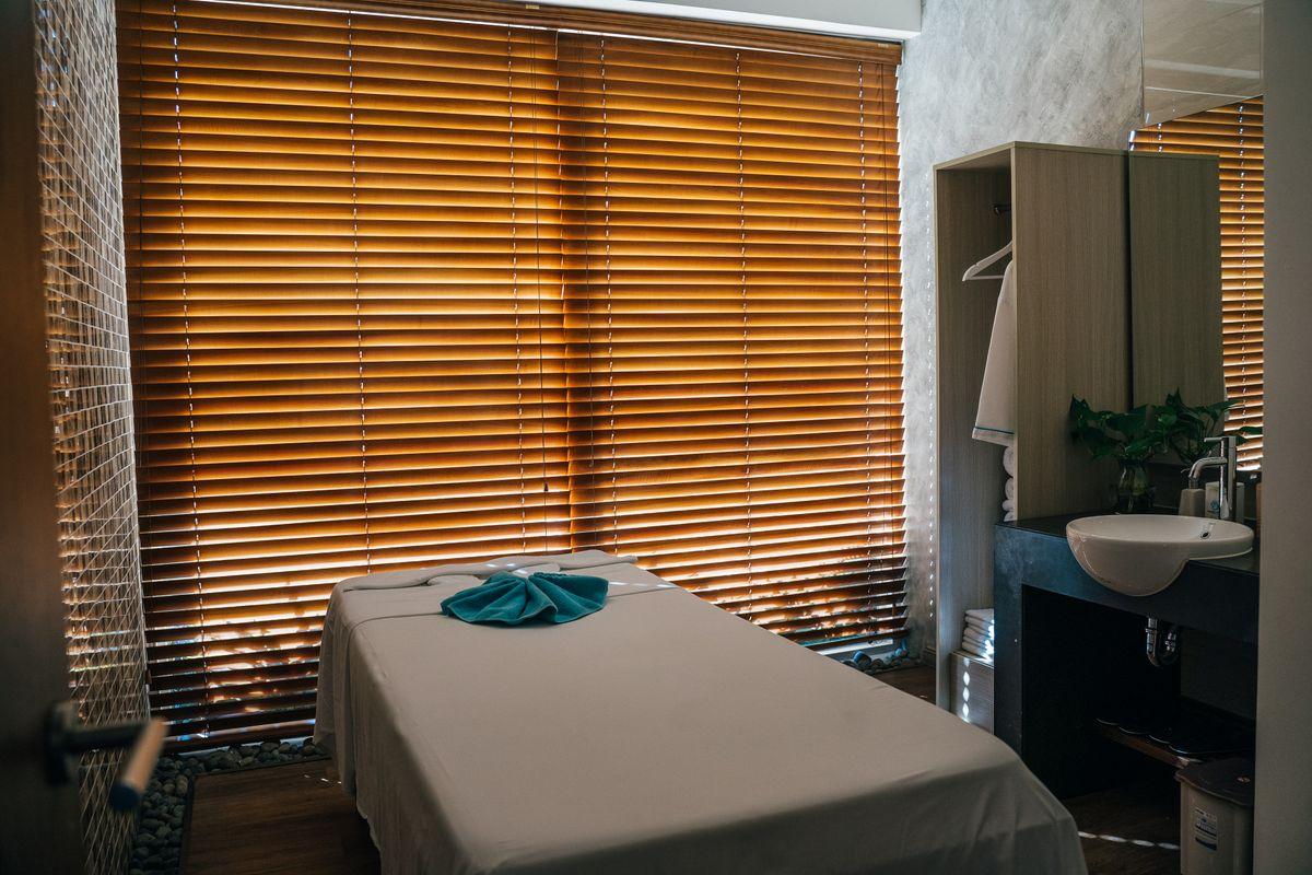 Empty massage room with warm wooden window blinds