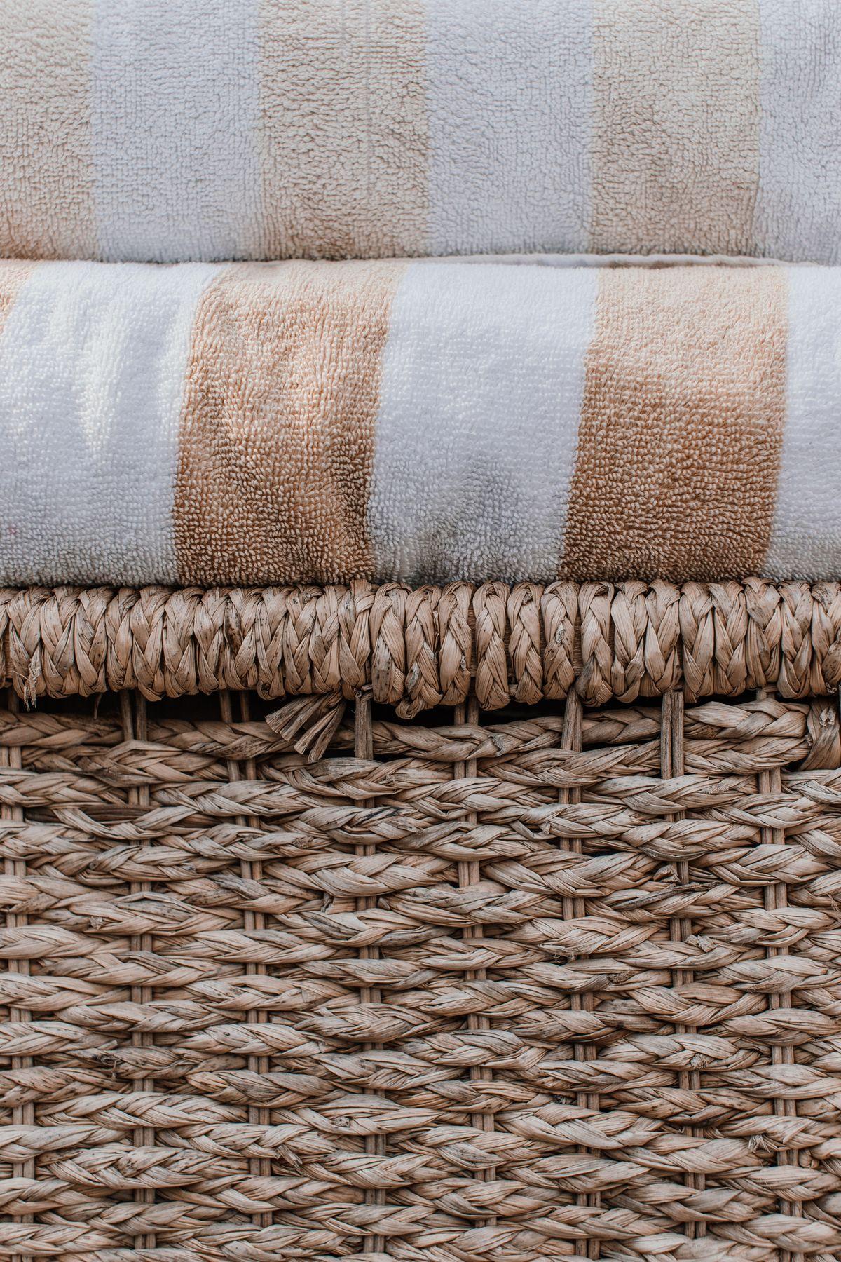 Folded striped towels in a wicker basket